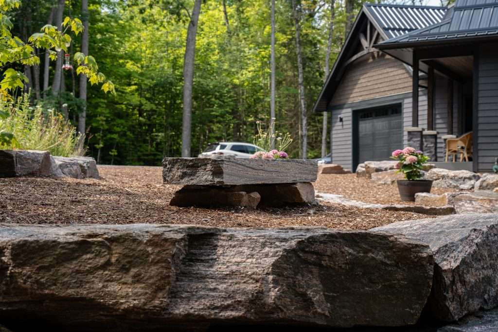 Armour stone and natural stone landscaping in front of a cottage